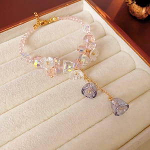 Detail of pink crystal flower bracelet with gold accents in a beige velvet jewelry box