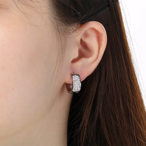 Close-up of a silver U-shaped stainless steel earring with pavé zircon stones on an ear