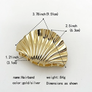 Golden shell-shaped metal hair claw clip with detailed stripe texture for thick hair
