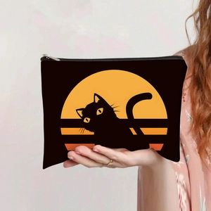 Trousse à maquillage vintage en toile avec chat noir et lune jaune tenue à la main