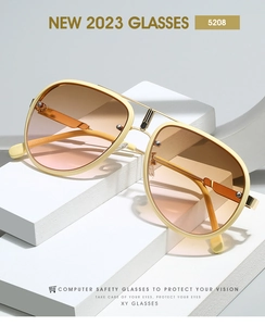 Close-up of cream aviator sunglasses with gold metal frame and gradient tea pink lenses