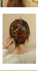 Detail of a knitted cherry hair claw clip with red wool berries on a woman's updo hairstyle