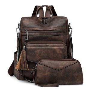 Detailed close-up of brown vintage leather backpack with stylish tassel charm and texture