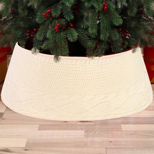 Close-up of cream knitted Christmas tree skirt with classic cable stitch patterns