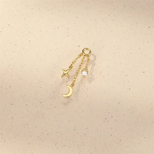 Macro detail of gold S925 silver star and moon pendant earrings with crystal stones