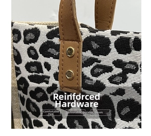 Detail of leopard print tote featuring woven fabric with leather handle and gold rivets