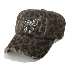 Gros plan d'une casquette léopard avec nœud en strass et bords usés stylisés