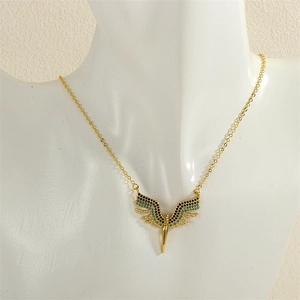 Close-up of gold wing necklace with blue and white zircon stones on a mannequin