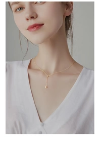 Nahaufnahme der minimalistischen Gold s925 Silber Perlenkette an einem weiblichen Hals
