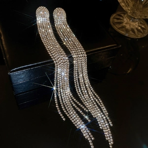 Macro view of silver tassel earrings with cascading crystals and star-shaped sparkles