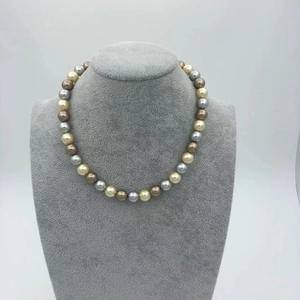Close-up of multicolored pearl necklace featuring gold, silver, brown, and cream beads