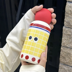 Close-up of 350ml colorful stainless steel kids bottle with cute pattern and red ball lid