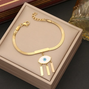 Gold evil eye bracelet with lucky engraving and tassels in a jewelry box presentation