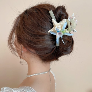 Detail of beach hair clip with fabric flower, starfish and pearls on model