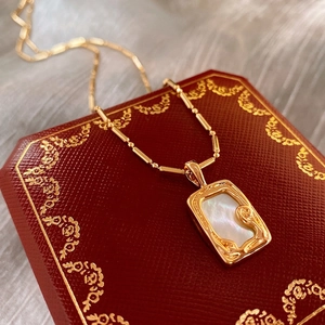 Gold plated square necklace with mother of pearl pendant on red vintage jewelry box