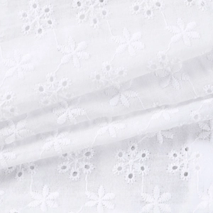 Vue macro détaillée de la broderie florale ajourée blanche sur le haut en dentelle