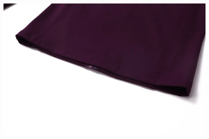 Detailed close-up of dark purple yoga jacket hem featuring high-quality stitching and zipper