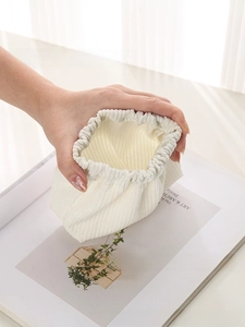 Close-up of a mini cream corduroy squeeze pouch with shrapnel closure for lipstick and coins