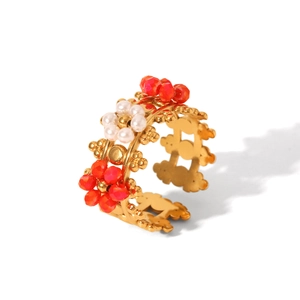 Détail d'une bague couronne vintage avec perles rouges et blanches à motif floral