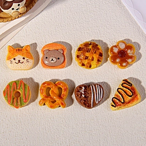 Detailed overhead shot of eight assorted miniature resin food charms including cute breads