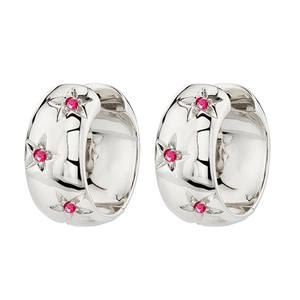 Macro detail of silver hoop earrings with engraved stars and red zircon stones