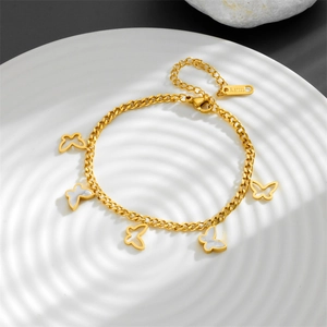 Detail of gold butterfly bracelet with white shell inlays on wavy textured plate
