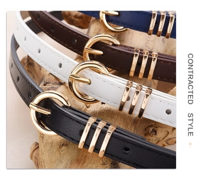 Detail view of four leather belts in black white brown and blue with golden D-ring buckles