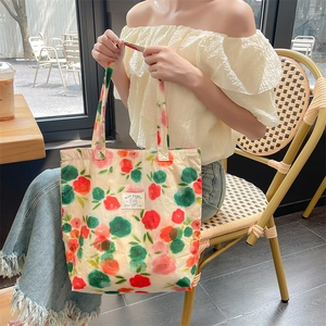 Close-up of lifestyle canvas tote bag with floral pattern and brand label detail
