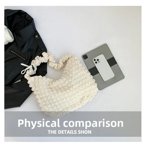 Detailed view of white popcorn texture shoulder bag shown with tablet for capacity