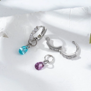 Detailed macro view of silver hoop earrings with detachable blue and purple stone drops