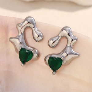 Detail of silver heart stud earrings with green gemstones on a pink seashell