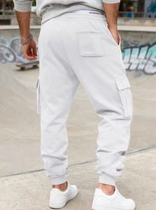 Detail view of white men's cargo sweatpants with flap pockets and jogger style back view