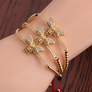 Lot de trois bracelets abeille dorés avec zircons colorés et cordons rouges réglables