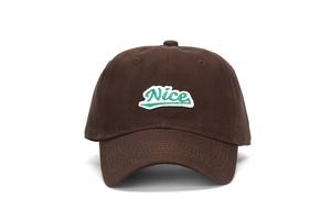 Détail de la broderie Nice sur casquette de baseball en coton marron foncé style urbain