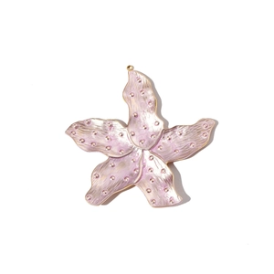 Detailed macro view of pink enamel starfish pendant with golden metal trim and dots