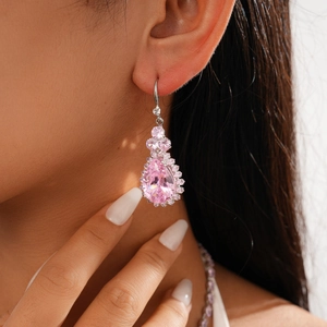 Close-up of pink pear-cut zircon earrings on model with sparkling silver setting