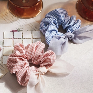 Detail of handmade plaid scrunchies with bow ribbons in blue and pink fabric