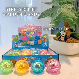 Macro view of squishy sugar ball toy with glitter inside blue packaging on wooden desk
