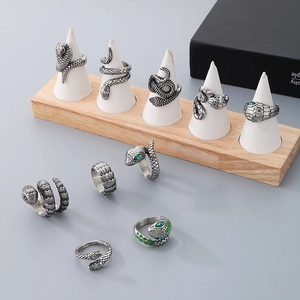 Detailed view of vintage silver snake rings with green zircon eyes on a display stand