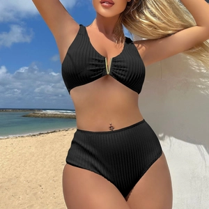 Close-up of ribbed black high-waisted bikini set with decorative gold V-shaped hardware