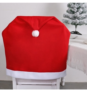 Detail showing red velvet Christmas chair cover with white pom-pom on a white chair