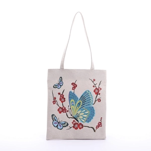 Detailed close-up of canvas tote bag featuring vibrant butterfly and plum blossom print