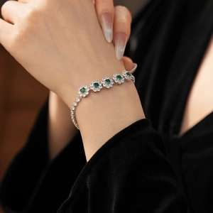 Vue détaillée d'un bracelet fleur en argent avec pierres vert émeraude et zircons
