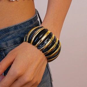 Macro detail of chunky stretch bracelet with black marble resin and gold metal links