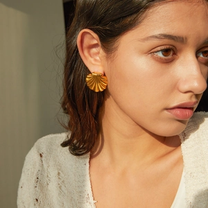 Golden fan-shaped shell earrings in 18k gold plated stainless steel on model