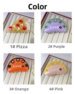 Detail of four colorful acetate claw clips with LOVE lettering and pizza patterns