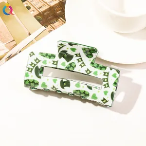Detail of St. Patrick’s Day hair claw clip with green clover and festive hat patterns