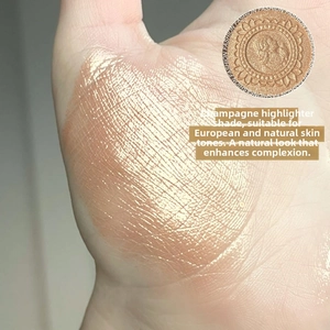 Macro shot of champagne highlighter shimmer swatch on hand showing fine pearlescent texture