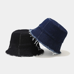Detailed view of frayed edges and contrast stitching on vintage denim bucket hats
