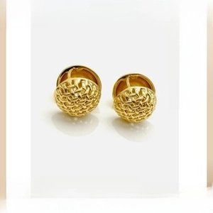 Macro detail of gold-plated woven texture hoop earrings with elegant mesh design